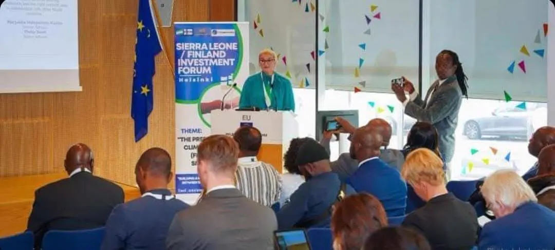 Speaker addressing delegates beneath the Sierra Leone-Finland Investment Forum banner in Helsinki